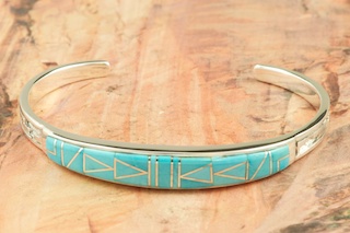Genuine Sleeping Beauty Turquoise inlaid between ribbons of Sterling Silver.  Stunning Sterling Silver Bracelet. Designed by Navajo Artist Calvin Begay. Signed by the artist.
